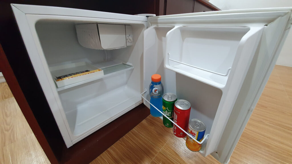 Mini refrigerator in the room with a couple of drinks available for a fee 